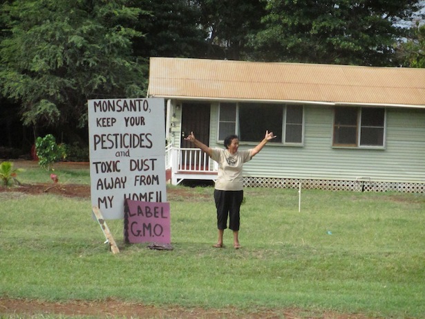 A Molokai resident expresses joy as the march passes by her home, which is located across the street from Monsanto's fields. (WNV/Imani Altemus-Williams)