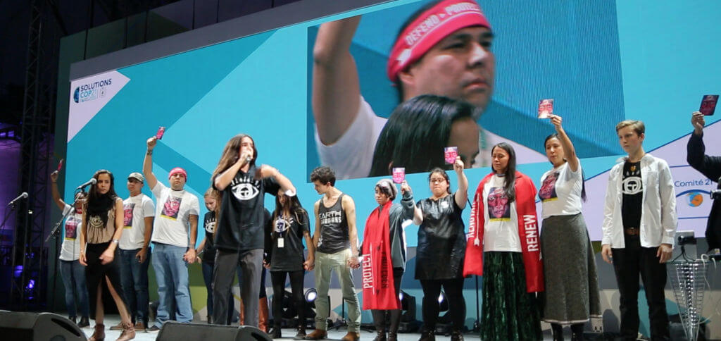 Indigenous activists protest at the COP21 Solutions Concert. Image via indigenousrising.org