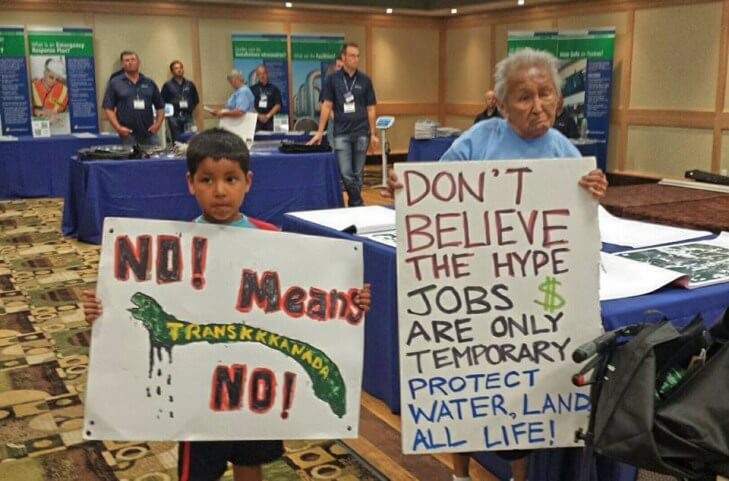 Nancy Morrison de 85 años, de Onigaming, y Daryl “Hutchy” Redsky Jr., 7, de Shoal Lake 40 protestan juntos en la segunda sesión informativa del oleoducto de Energy East en Kenora. 